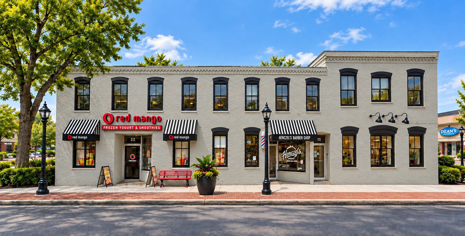 Two-storey white brick building with shops under striped awnings along a tree-lined street